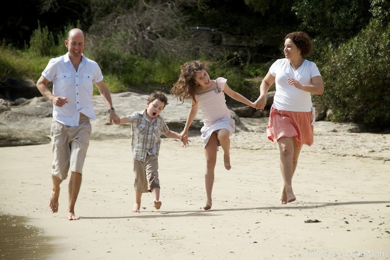 family running along beach - family portrait photography